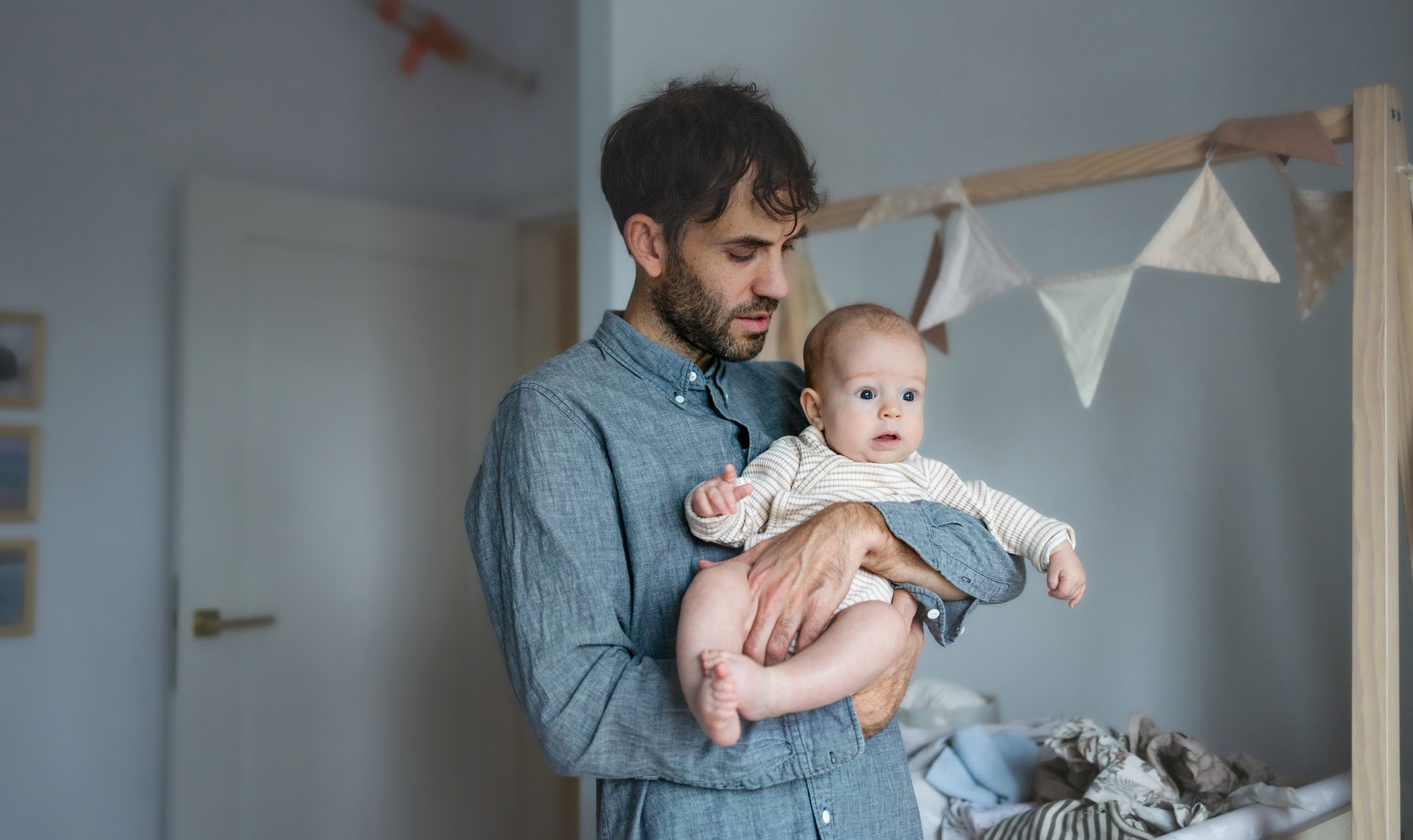 Dad holding baby in nursery