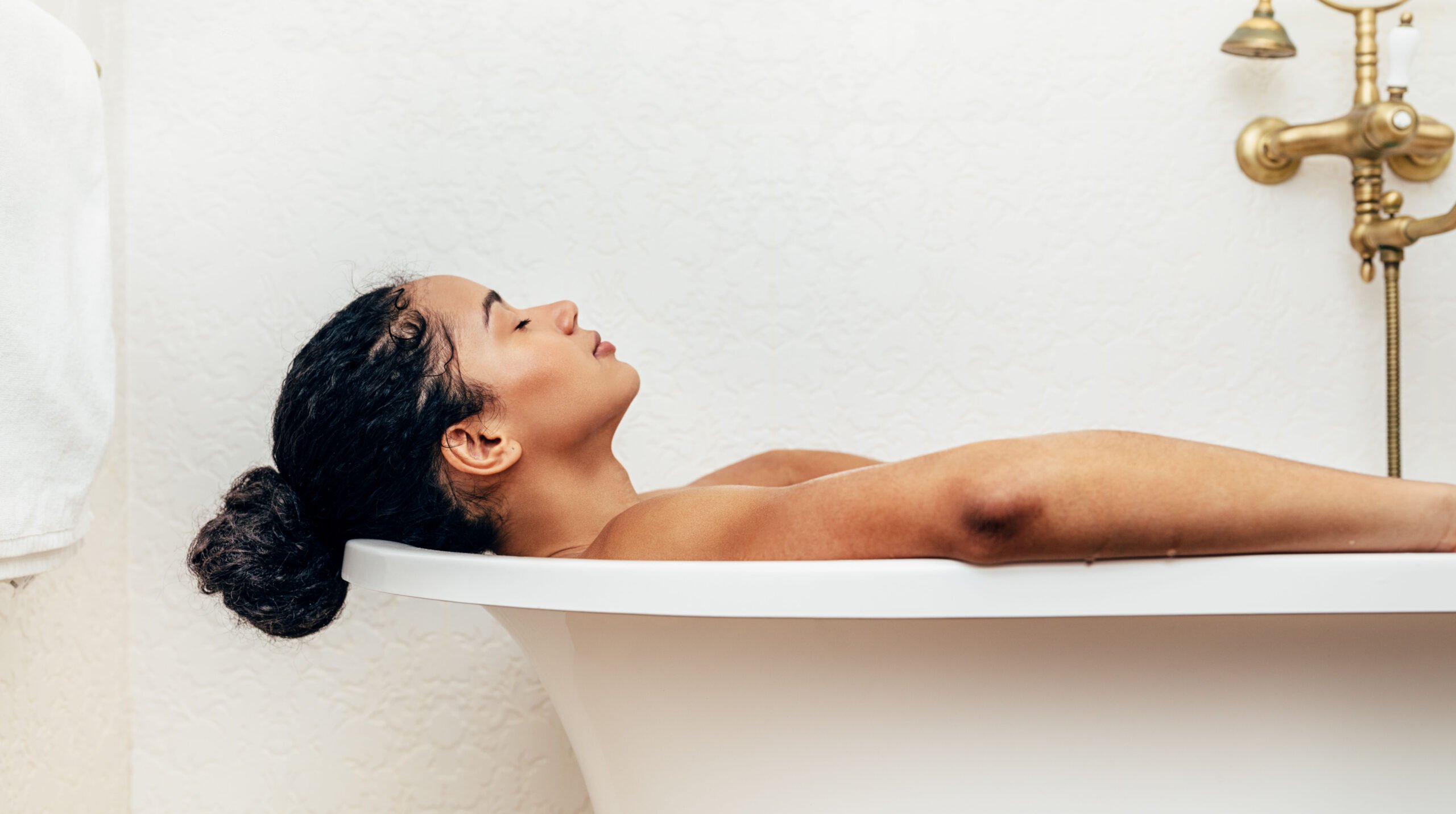 Side view of young woman having a bath