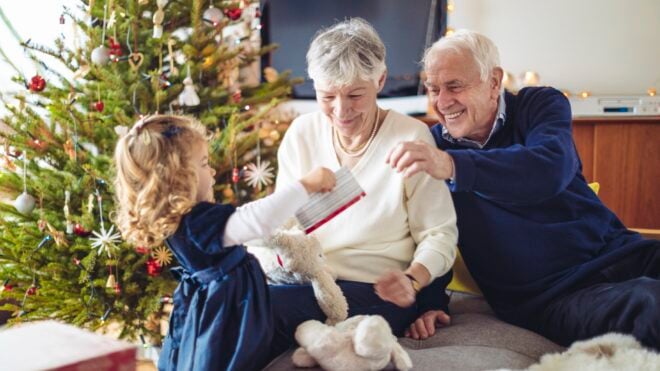 Grandparents giving a young girt her Christmas gifts