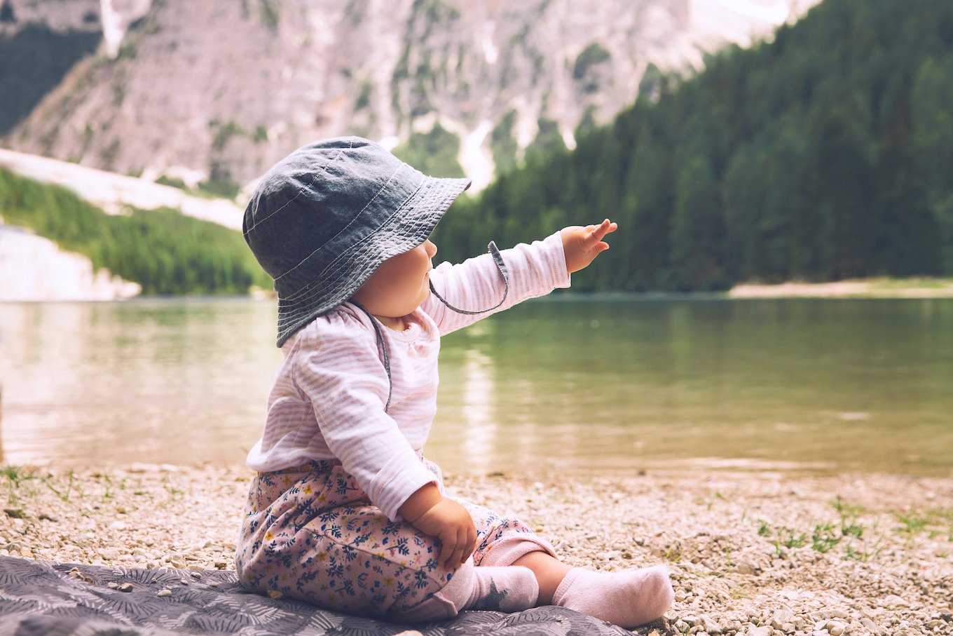Baby sitting by a lake