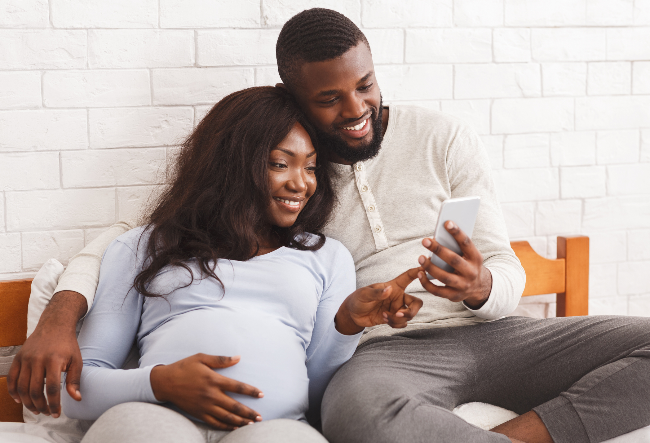 pregnant woman and partner looking at smartphone