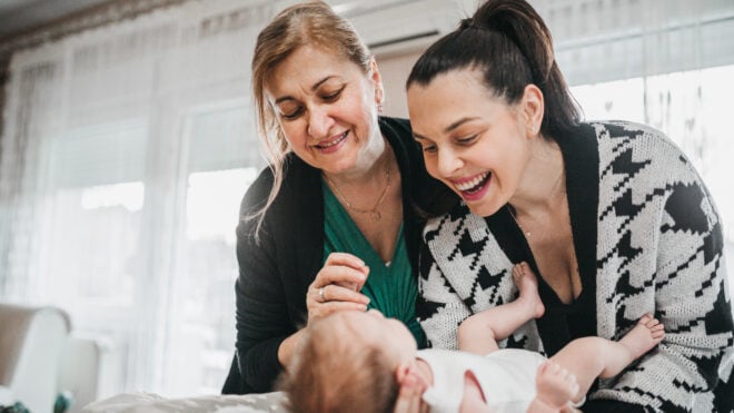 Changing baby's diapers, grandmother giving parenting advice