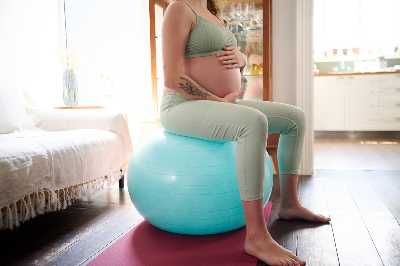Pregnant person on an exercise bal