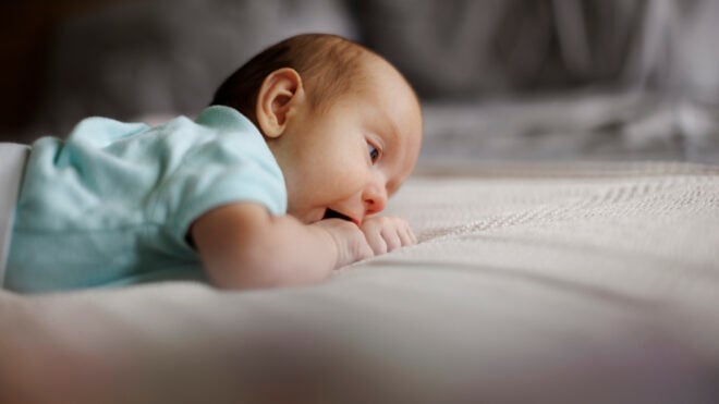 Cute little baby boy or girl lying on bed