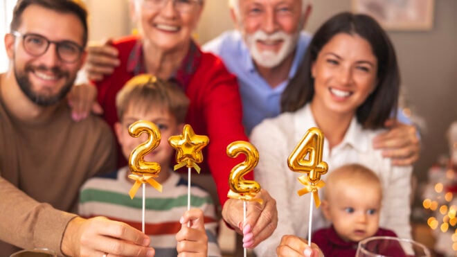 Family holding balloons shaped as numbers 2024