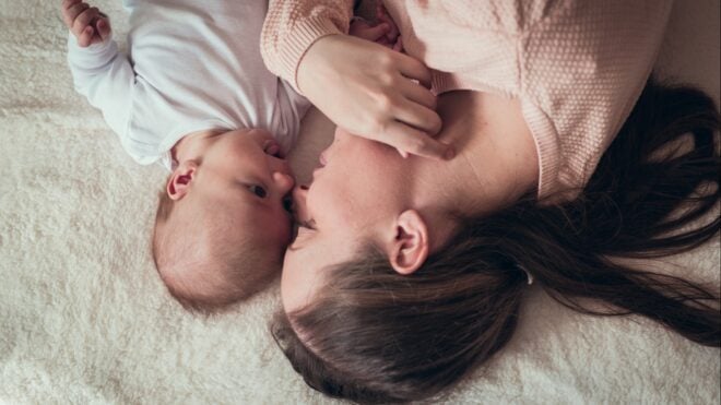 A woman lying with a baby
