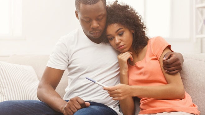 Couple-on-couch-looking-at-pregnancy-test